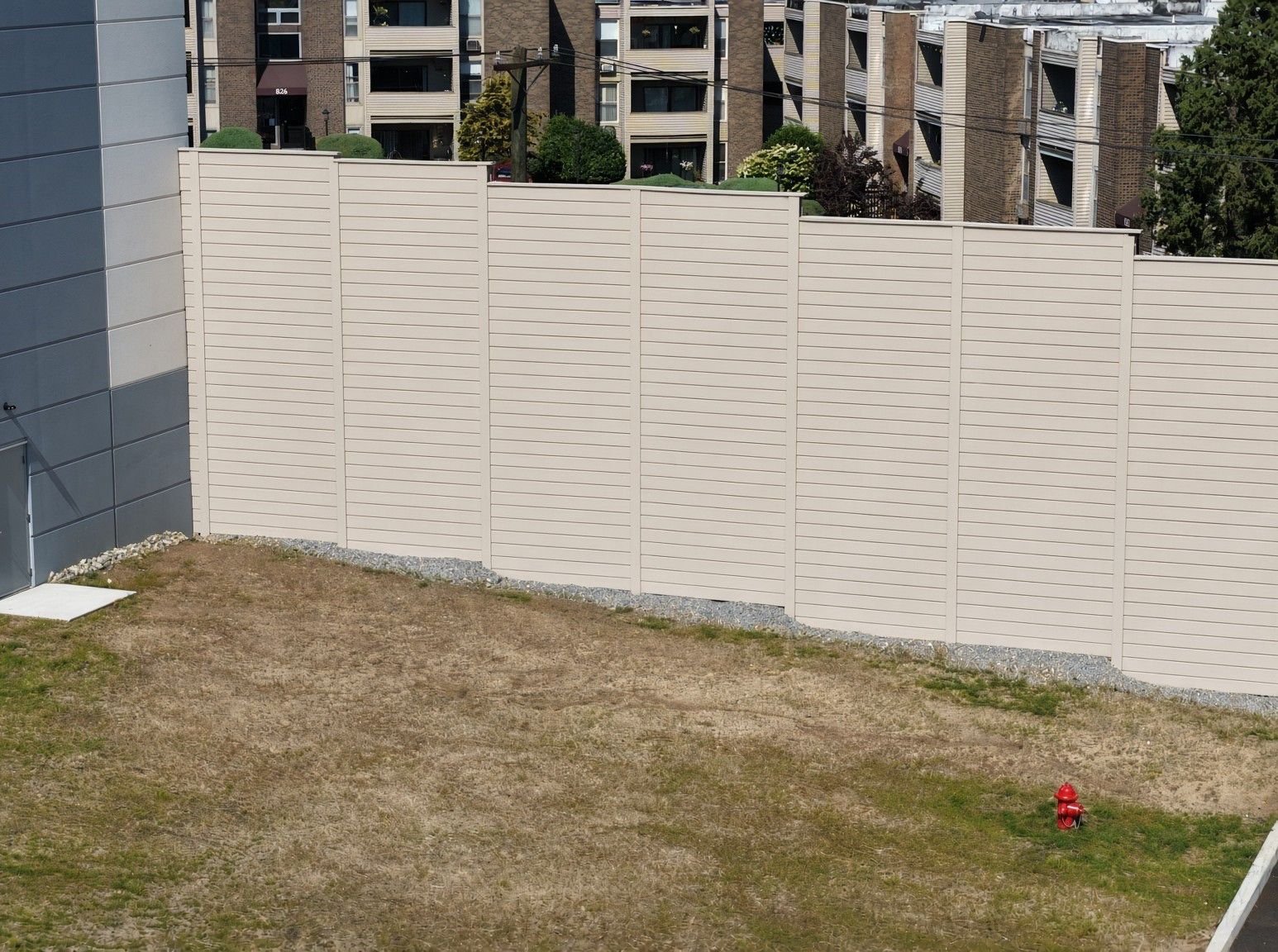 PlywallPVC barrier in beige beside apartment buildings