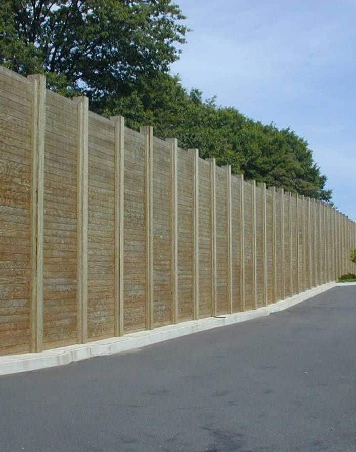 Tall Plywall wood noise barrier along a curved road